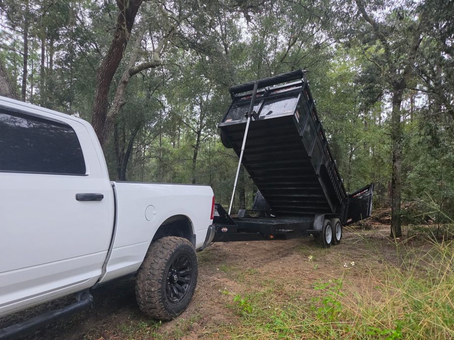 Dump trailer raised behind the truck, unloading debris
