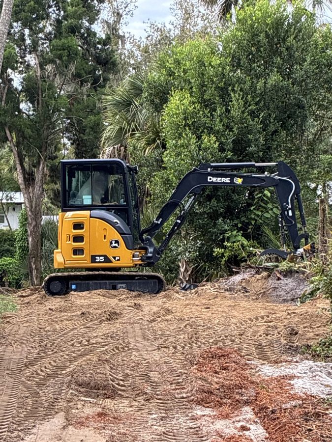 Compact excavator on a freshly cleared mound