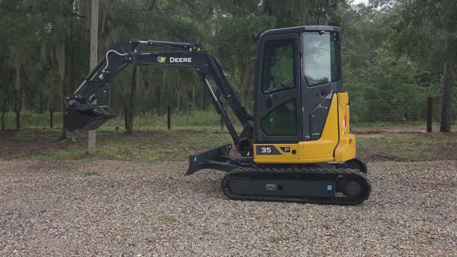 Compact excavator, side profile, on a gravel pad