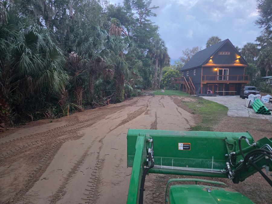 Graded sand driveway leading to a house