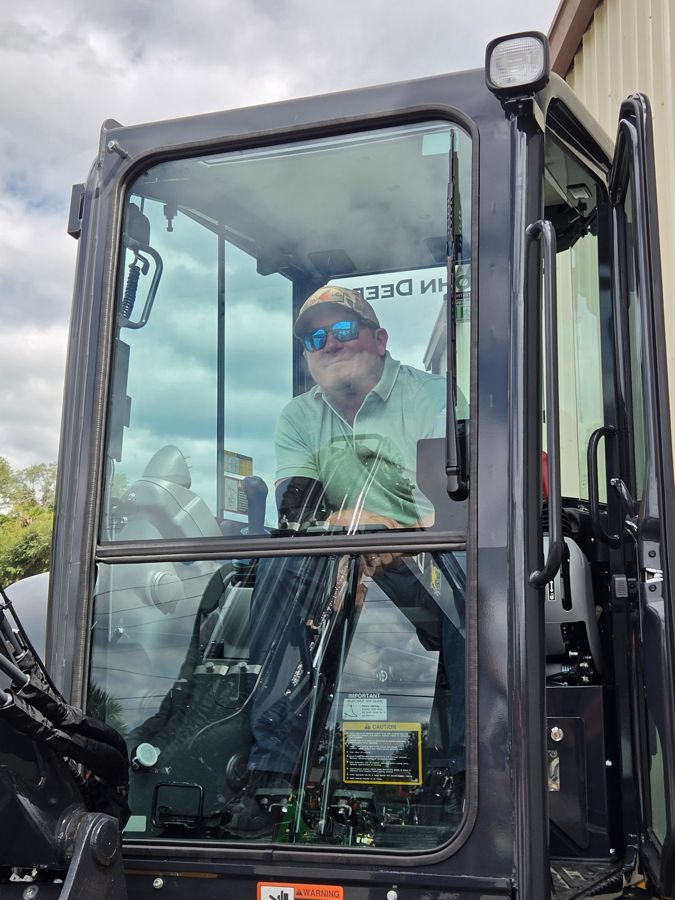 Jason Singletary in the cab of the excavator, door open